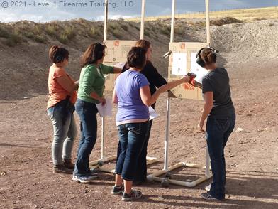 IMAGE: Idaho Women's Only Workshop Pistol Class checking targets at the range.